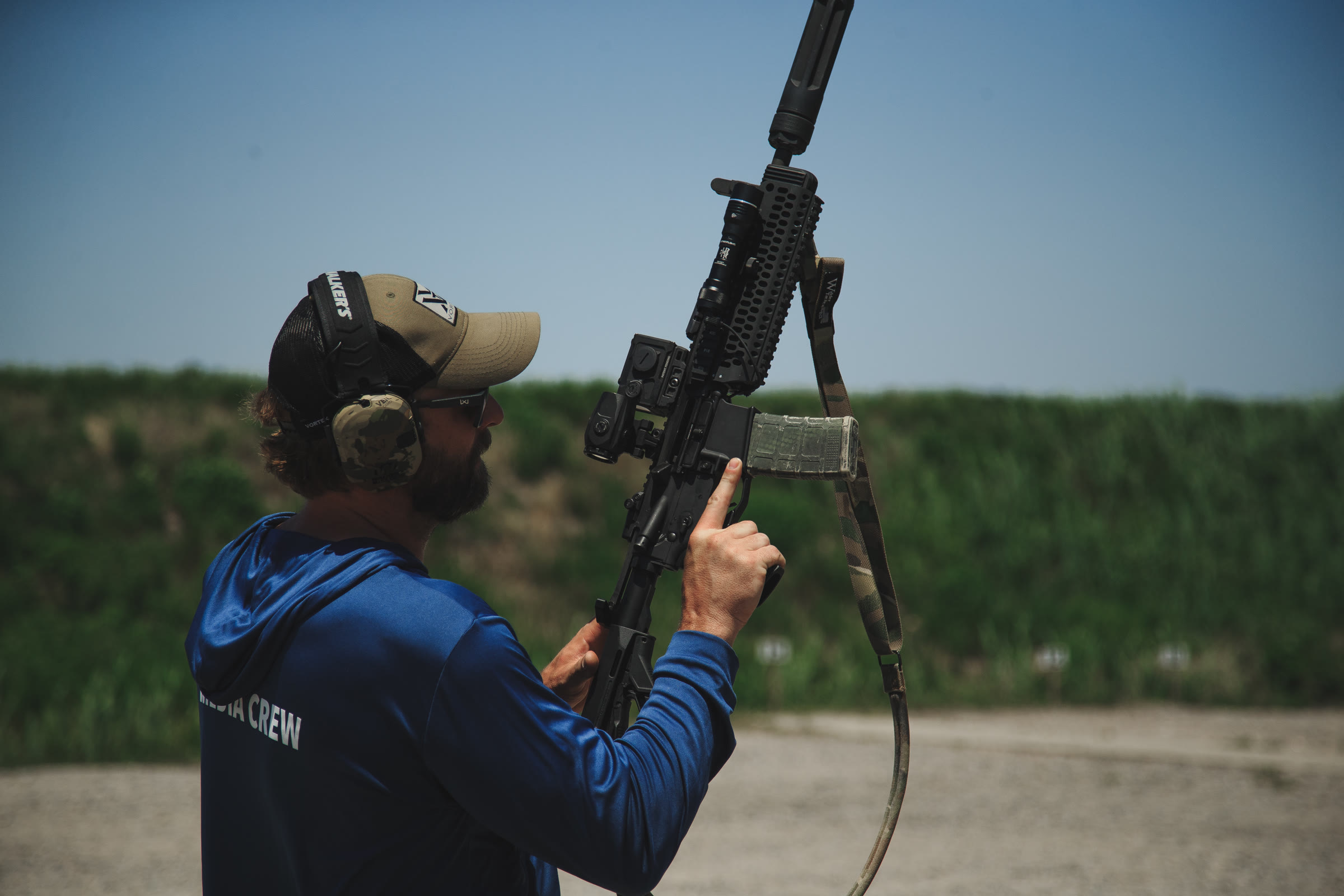 Operator clearing an opening with a suppressed carbine